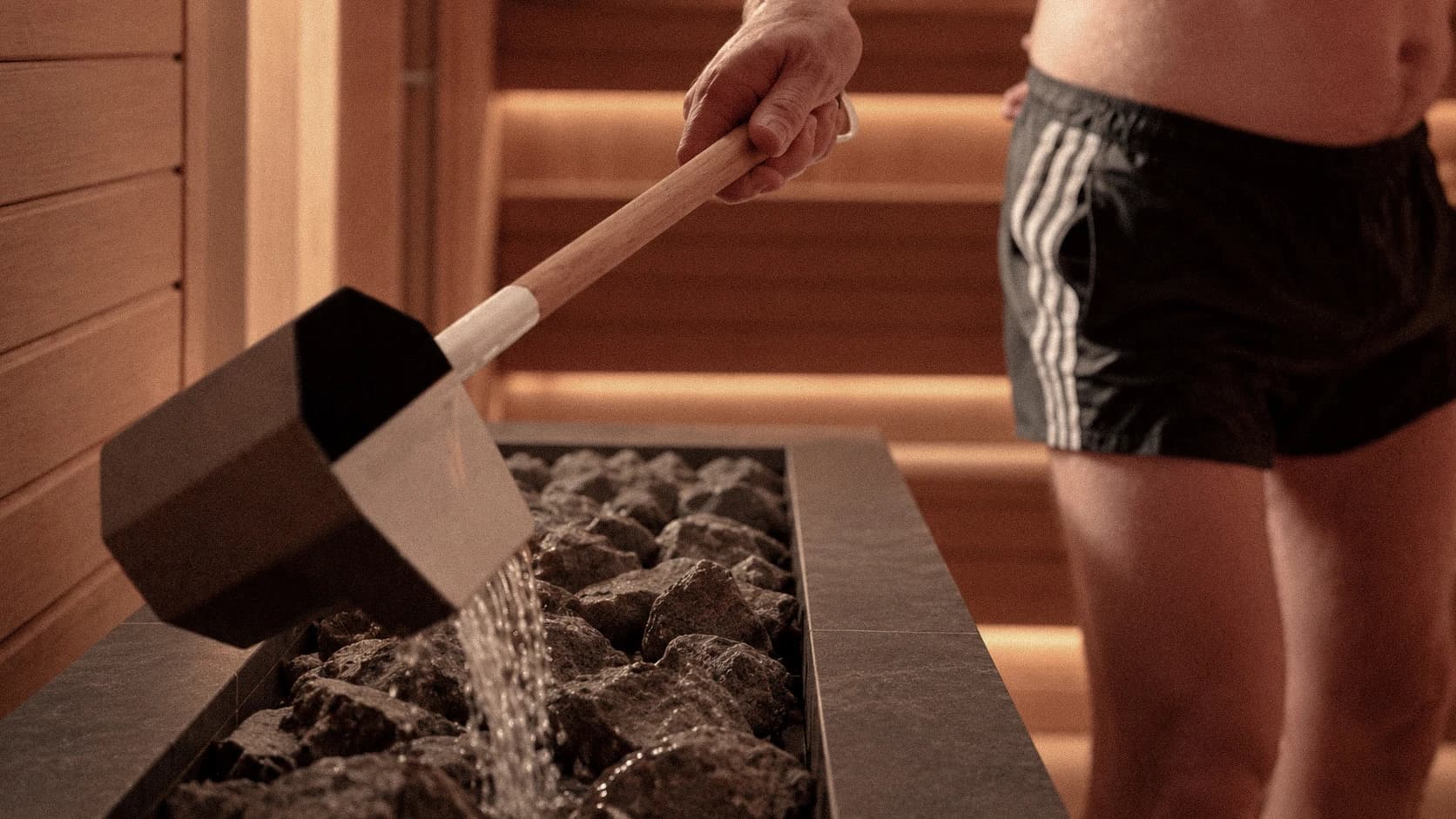 A facilitator pouring water over the stones